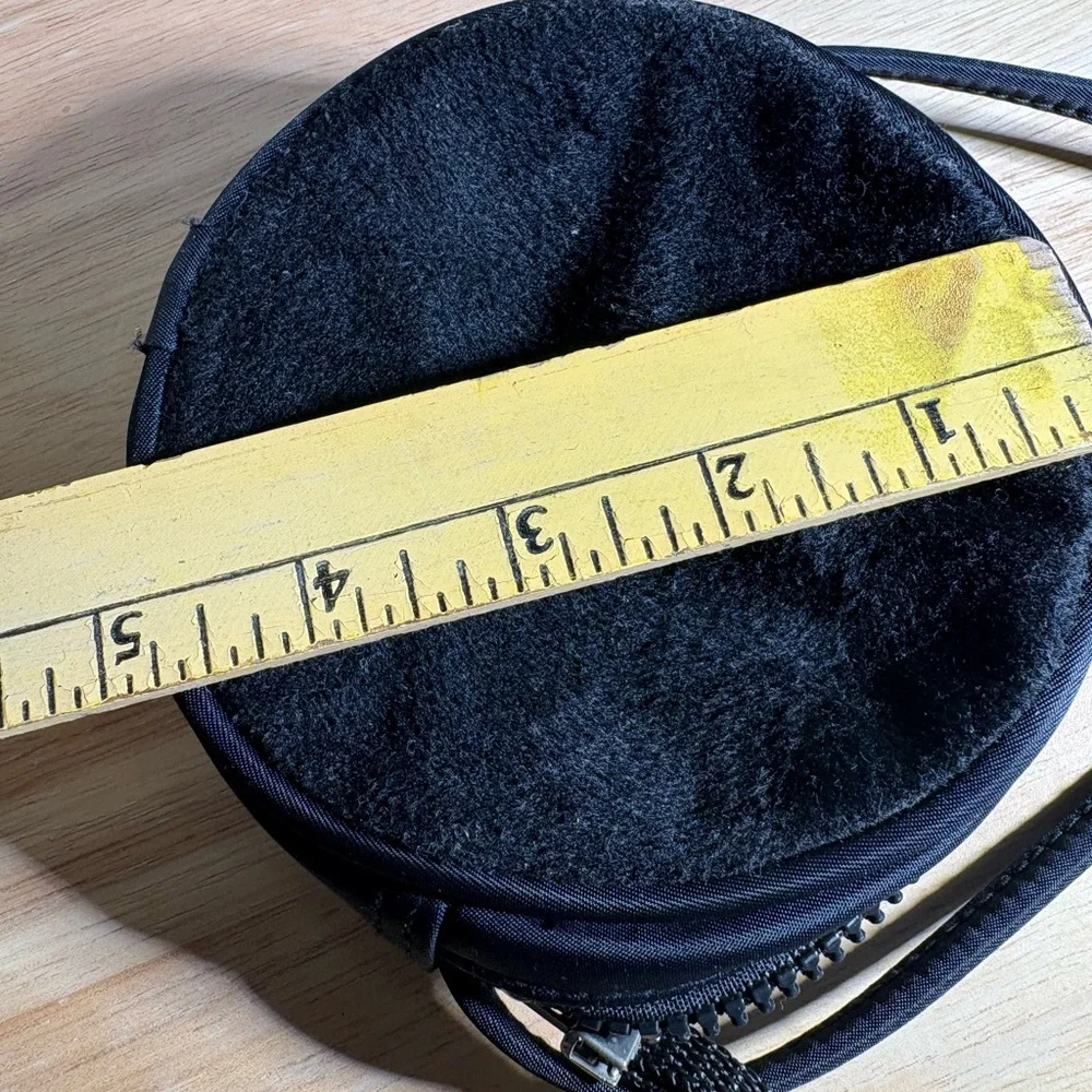 Women’s Round Black Crossbody Bag with zipper closure.
